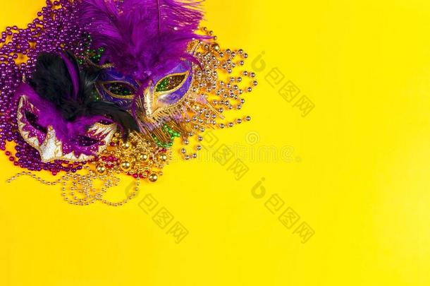 节日的狂欢节面具和小珠子向黄色的背景