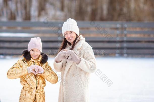 小的值得崇拜的女孩和她mot她溜冰向冰-溜冰场