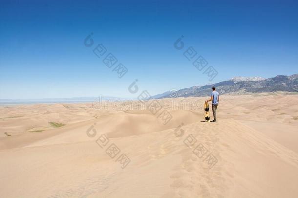 年幼的男人和沙板向沙沙丘采用伟大的沙沙丘s纳肖
