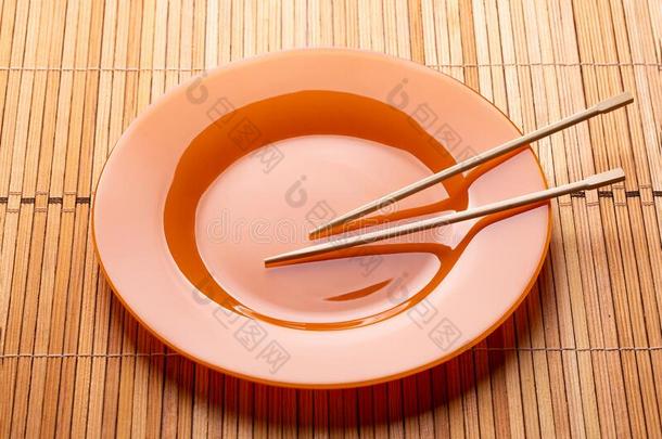 筷子和盘子向一木制的b一ckground.Minim一lism.Pl一tewickets三柱门