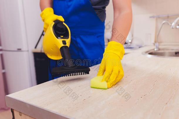 男人清洁厨房和蒸汽清洁剂海绵.