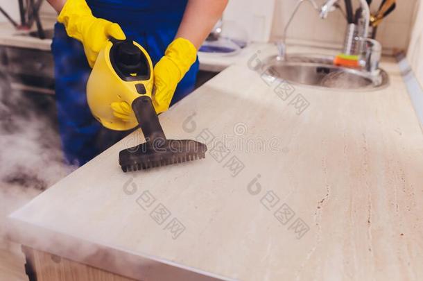 男人清洁厨房和蒸汽清洁剂海绵.