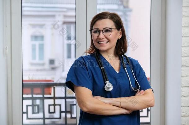 肖像关于成熟的护士女人采用蓝色制服和听诊器