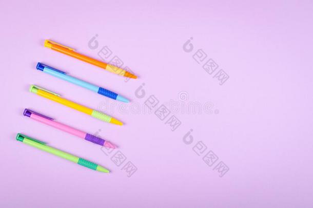不同的有色的笔,学校圆珠笔向紫色的背景Colombia哥伦比亚