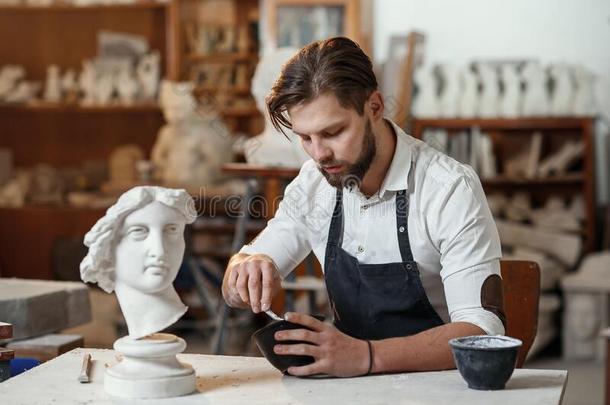 灵巧的雕刻家使专业的修复关于石膏雕刻
