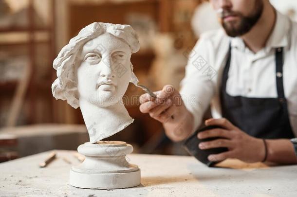 灵巧的雕刻家使专业的修复关于石膏雕刻