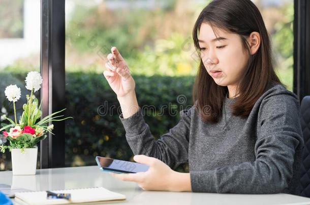 年幼的女人佃户租种的土地信誉卡片和使用智能手机