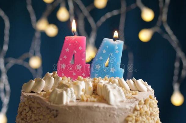 生日蛋糕和44数字粉红色的蜡烛向蓝色巴克格雷德
