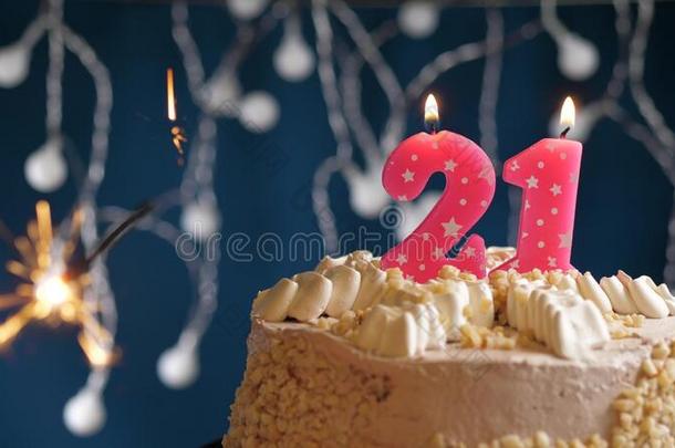 生日蛋糕和21数字粉红色的蜡烛和闪烁发光物向蓝色波黑