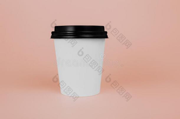 白色的纸咖啡豆或茶水杯子和黑的盖子向粉红色的背景.