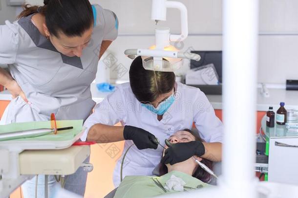 有阅历的医生牙科医生劝告年幼的住院实习医生关于处理轻拍