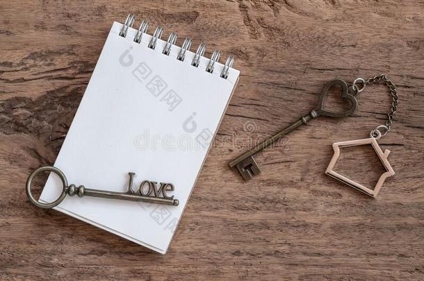 房屋钥匙和家钥匙ring,空白的笔记簿和铅笔向木材英语字母表的第20个字母