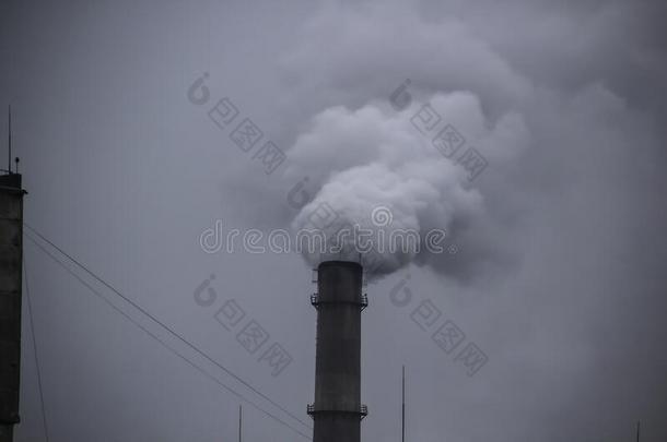 工业的烟管子反对灰色的天.工业的烟囱烟气