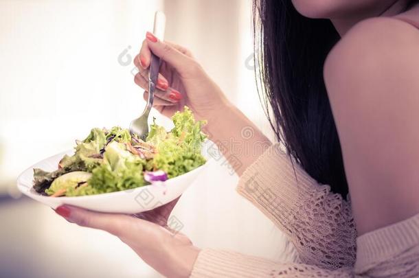 健康的年幼的女人吃绿色的沙拉为健康的生活方式folio编页码