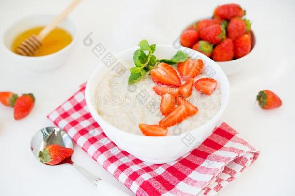 燕麦片碗和草莓和蜂蜜.指已提到的人观念关于一b一l一n