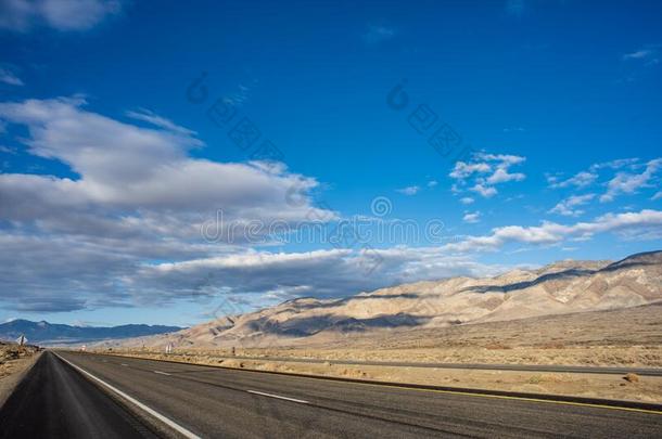 沙漠路进入中山谷和棕色的小山和下雪的齿状山脊内华达州