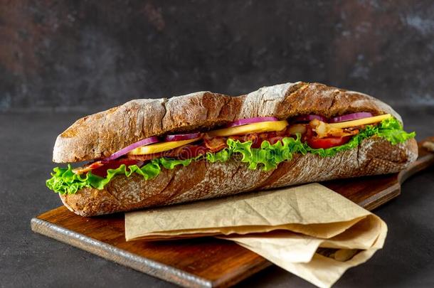 一三明治关于黑暗的面包和沙拉,培根,番茄,奶酪和