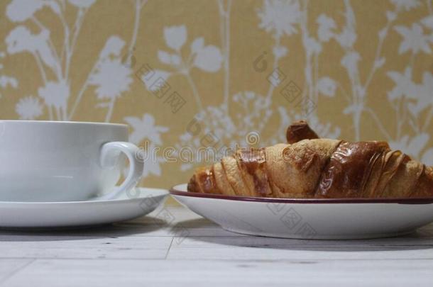 法国的羊角面包和杯子关于茶水向茶杯托酿酒的