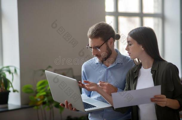 女孩和男人和便携式电脑谈论使<strong>工作计划</strong>.