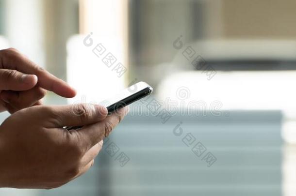 男人使用智能手机使用指已提到的人电话为使工作日常的互联网