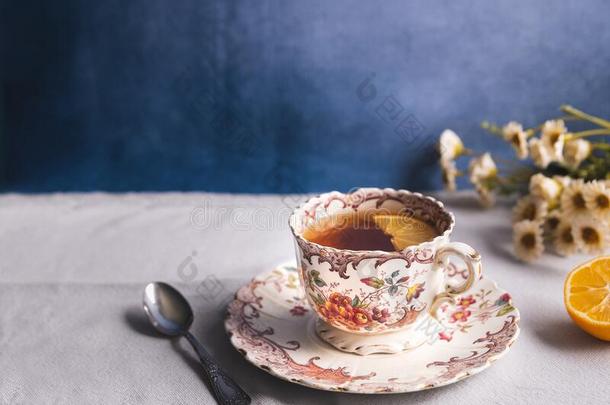 优美的花的酿酒的茶水杯子和茶水和柠檬切成片