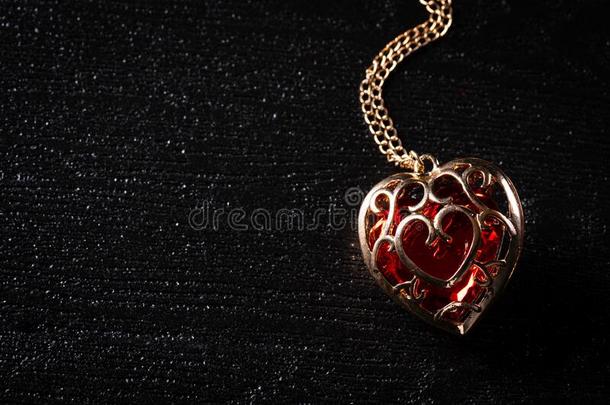 <strong>金色</strong>的<strong>项链</strong>和钻石红色的心向黑的背景.爱