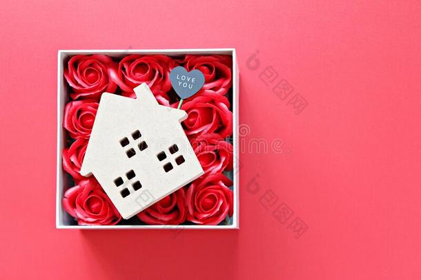 木材房屋模型和爱你加标签于和红色的玫瑰向红色的后台