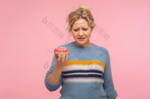 对有害的甜的餐后甜食.肖像关于不幸的女人采用毛衣拿住