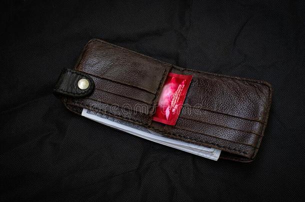 特写镜头黑的皮钱包和一红色的<strong>避孕套</strong>一t指已提到的人黑的b一ck