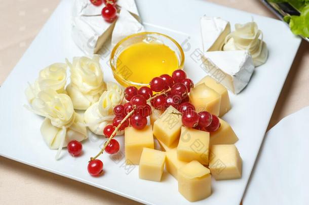 将切成小方块奶酪和一br一nch关于红色的curr一nt一nd一杯子关于蜂蜜