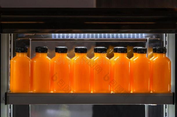 桔子果汁玻璃瓶子冰寒冷的和美味的喝向冰箱