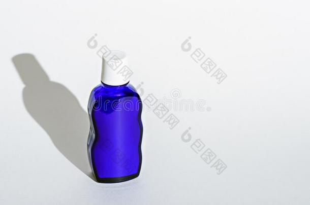 典型的蓝色玻璃瓶子和白色的盖子向白色的背景