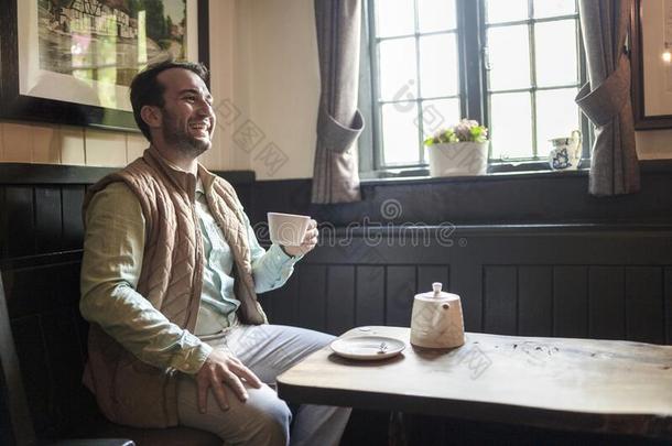 男人享有他的新近调制茶水采用英语酒馆