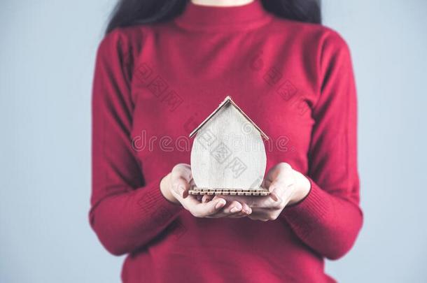 女人手木制的房屋模型