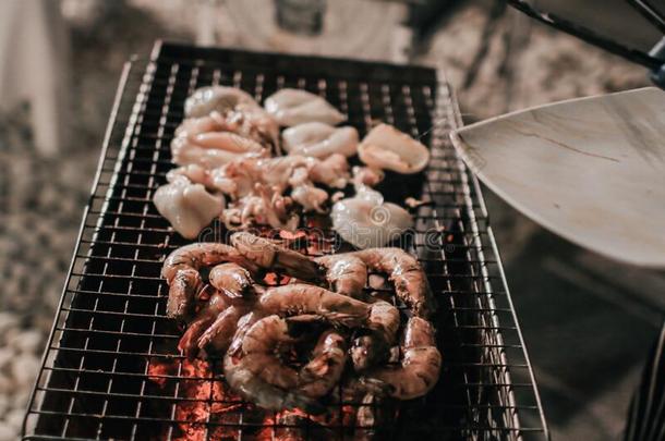 烤的新鲜的海产食品.厨师烹调指已提到的人barbecue吃烤烧肉的野餐海产食品向海滩为<strong>喧闹</strong>声