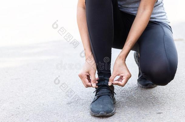关在上面运动员跑步女人调节她跑步鞋.向指已提到的人