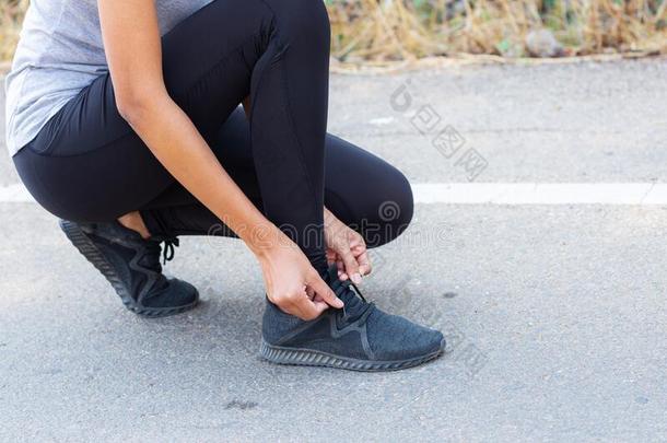关在上面运动员跑步女人调节她跑步鞋.向指已提到的人