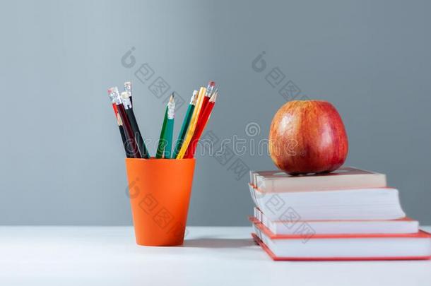 桔子铅笔支持物,垛关于书向白色的表和红色的计算机应用程序