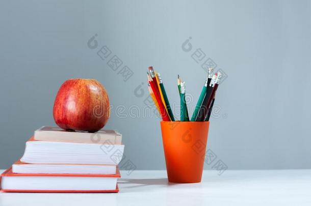 桔子铅笔支持物,垛关于书向白色的表和红色的计算机应用程序
