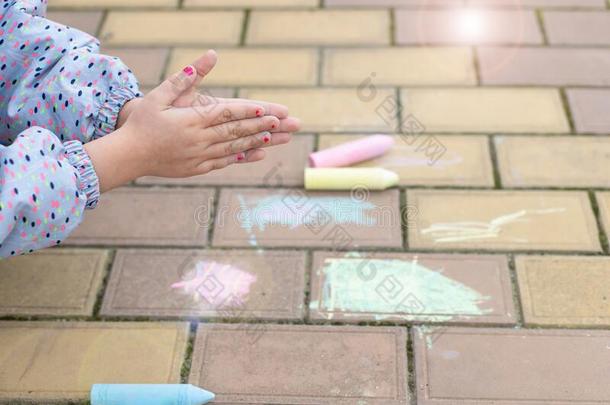 小的女孩清洁恶劣的手,后的绘画和粉笔向指已提到的人