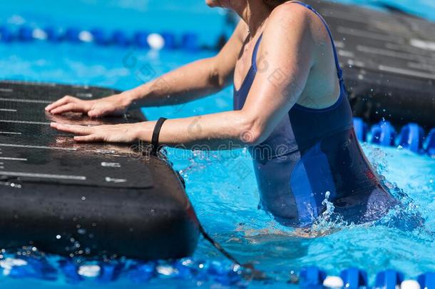 女孩做练习向不固定的健康席子采用一户外的游泳