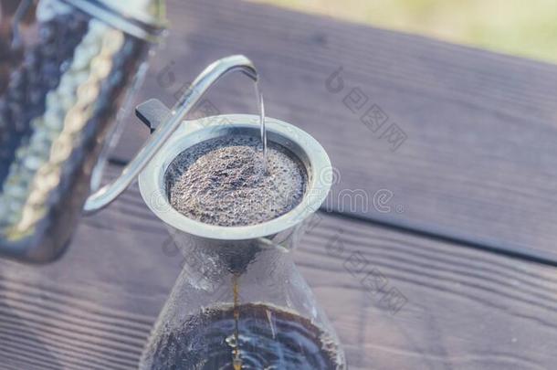 手滴下咖啡豆制造涌出越过咖啡豆和热的水存在便壶