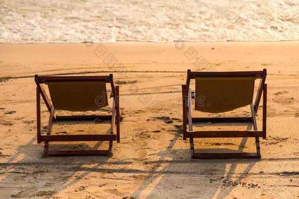 一对关于椅子向日落海滩
