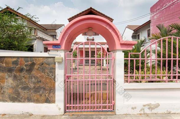欢迎粉红色的门,粉红色的栅栏白色的墙,石头墙.一房屋