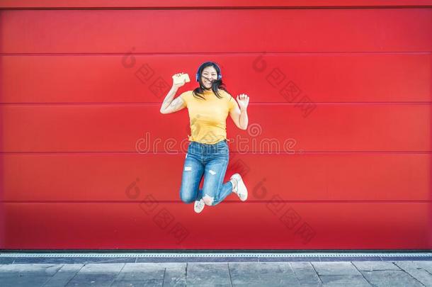 亚洲人<strong>疯狂</strong>的女孩用于跳跃的和收听的<strong>音乐</strong>户外的-幸福的希腊字母的第22字