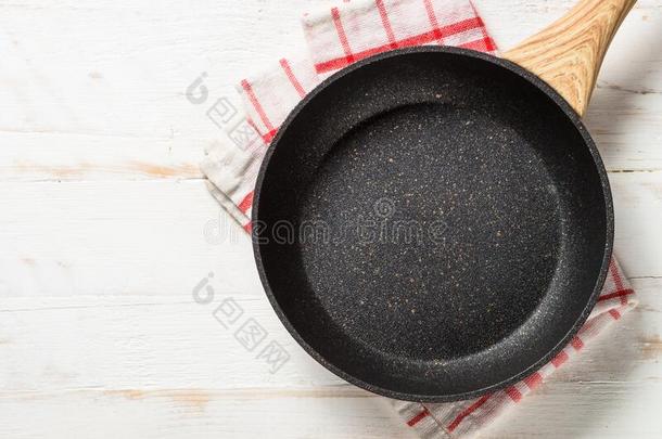 油炸平底锅或煎锅向白色的木制的表.