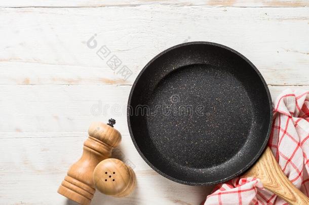 油炸平底锅或煎锅向白色的木制的表.