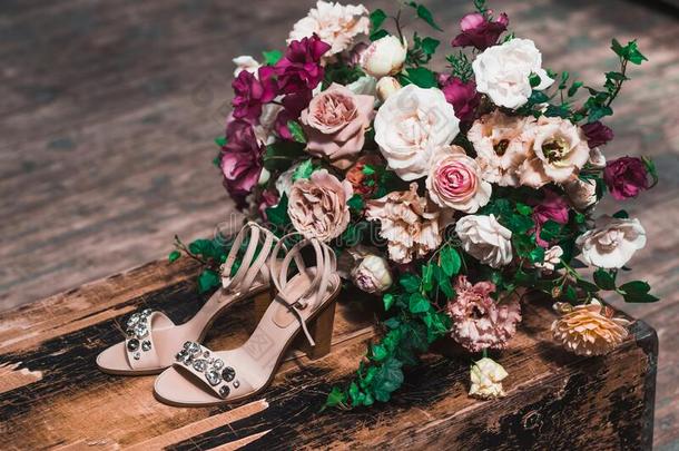 新娘鞋子和宝石和被环绕着的在旁边花安排