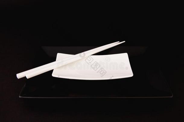 黑的和白色的空的寿司盘子和白色的竹子筷子
