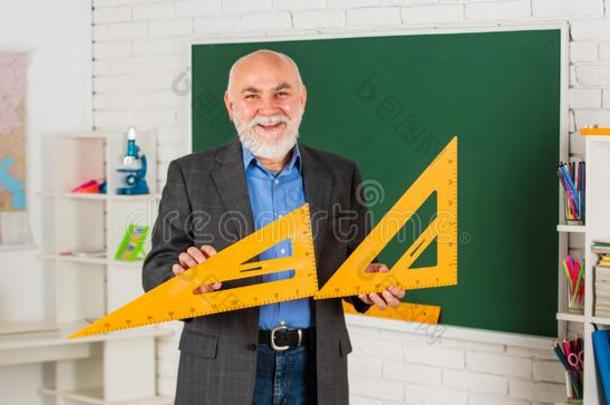 解决数学的问题.成熟的男人教师使用数学三角铁